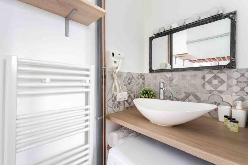 une salle de bain avec un lavabo blanc et un miroir dans l'établissement M2- Modern Loft in Le Marais, Bright and Comfortable, à Paris