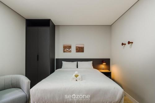 a bedroom with a bed with two white towels on it at TCO - Apartamentos no Centro Histórico Porto Alegre/RS in Porto Alegre