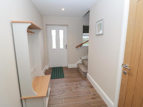 un pasillo con una puerta y una alfombra verde en Breamish, en Alnwick