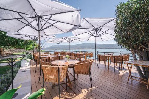 a wooden deck with tables and chairs with umbrellas at Luxury Bungalow Lake view Cajititlan in Cajititlán