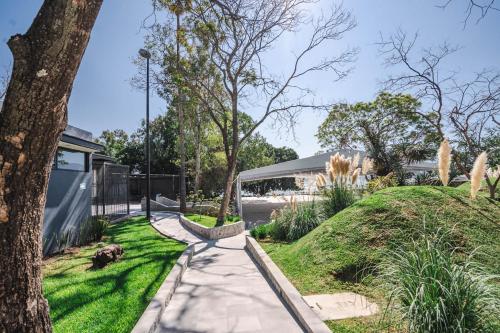 a walkway in a park with a tree and grass at Luxury Bungalow Lake view Cajititlan in Cajititlán