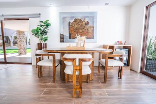 a dining room with a wooden table and chairs at Private Bungalow Cajititlan Pool in Cajititlán