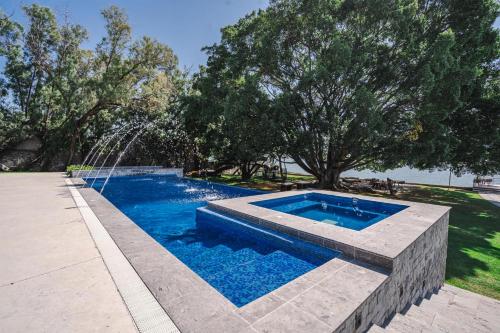 a swimming pool with a water fountain at Private Bungalow Cajititlan Pool in Cajititlán
