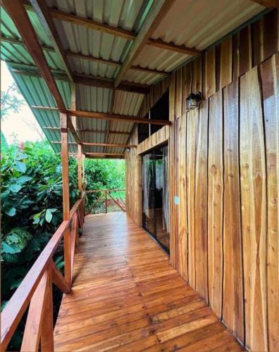 a wooden porch of a wooden house with a roof at Río Celeste, Cacahua Lodge in Rio Celeste
