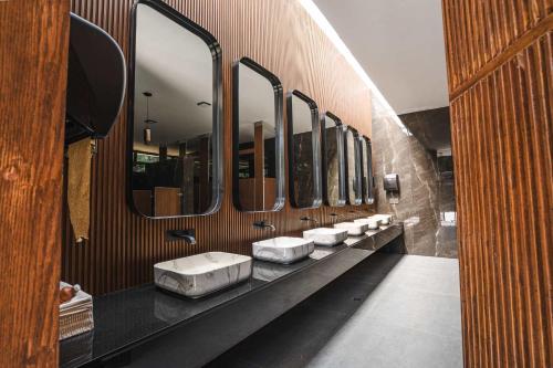 a row of sinks in a bathroom with mirrors at Bungalow Cajititlan 2 bedrooms & lake view in Cajititlán