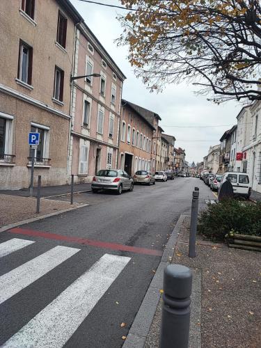 une rue vide avec des voitures garées sur le côté de la route dans l'établissement Chambre st Vallier, à Saint-Vallier