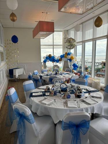 a dining room with tables and chairs with blue bows at Park Inn by Radisson Palace in Southend-on-Sea