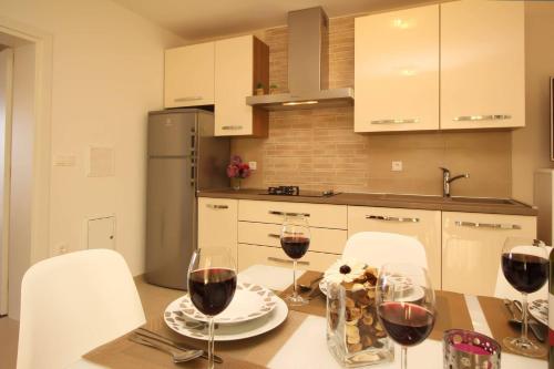 a kitchen with a table with two glasses of wine at Apartment Kristijan in Šilo