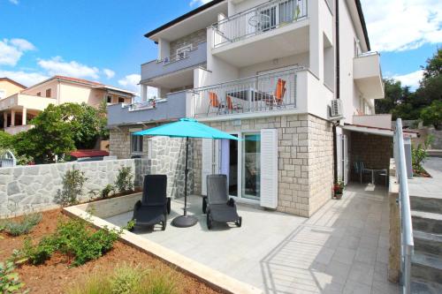 a patio with two chairs and an umbrella at Apartment Kristijan in Šilo