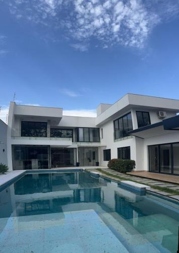 a large house with a swimming pool in front of it at Ziza Hospedagem in Maringá