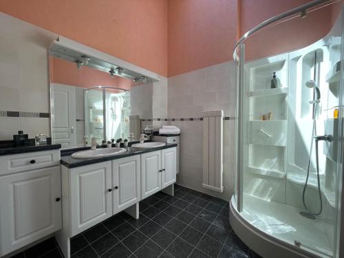 a bathroom with two sinks and a shower at Casa Verso, au bord du lac d'Annecy avec vue in Doussard