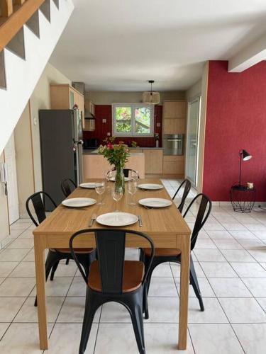 a dining room table with chairs and a kitchen at Casa Verso, au bord du lac d'Annecy avec vue in Doussard