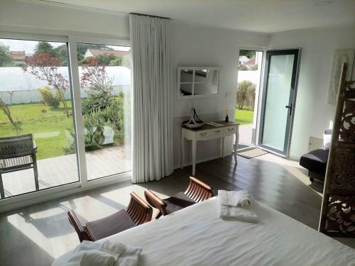 a bedroom with a white bed and a large window at La Finca de Ananás - Suite privada con entrada independiente in Ponta Delgada