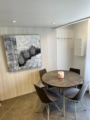une salle à manger avec une table et des chaises et un tableau dans l'établissement Coup de coeur au bord du lac, à Leucate-Plage