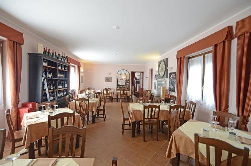 a restaurant with tables and chairs in a room at Relais Ristorante Sanfront in Ponzone