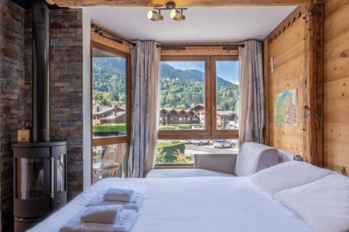 une chambre avec un lit et une grande fenêtre dans l'établissement Prarion - Modern apartment 4 pax Next to Ski lift - By Cozee Rentals, aux Houches