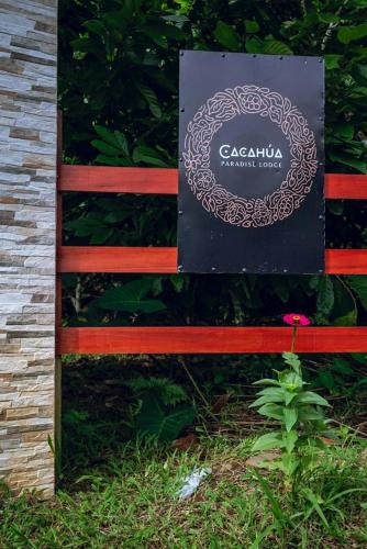 a sign on a wooden bench with a sign at Río Celeste, Cacahua Lodge in Rio Celeste