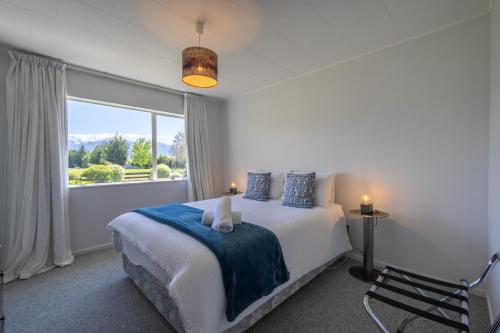 a bedroom with a bed and a large window at Kepler Retreat - Te Anau Holiday Home in Te Anau