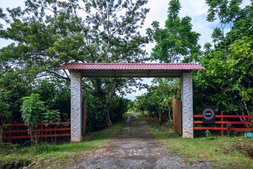 an archway on a dirt road with a fence at Río Celeste, Cacahua Lodge in Rio Celeste