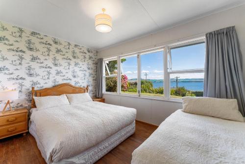 a bedroom with two beds and a window at Lakeview Cottage - Rainbow Point Holiday Home in Taupo