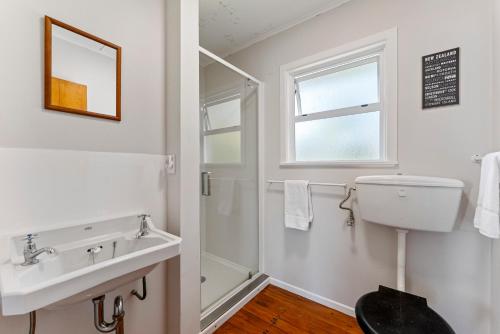 a bathroom with a sink and a toilet and a window at Lakeview Cottage - Rainbow Point Holiday Home in Taupo