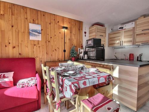 une petite cuisine avec une table et une chaise rouge dans l'établissement Studio divisible au pied des pistes avec balcon, WiFi et lave-linge - FR-1-455-250, à La Plagne Tarentaise