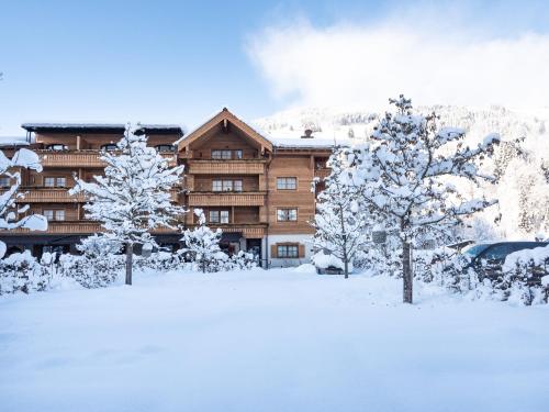 a ski lodge with snow covered trees in front of it at Der Unterschwarzachhof in Saalbach Hinterglemm