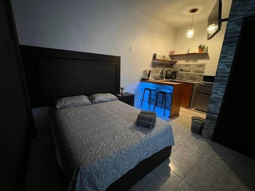 a bedroom with a bed and a kitchen with blue lights at Departamento PLAYA GRIS in Ciudad del Carmen