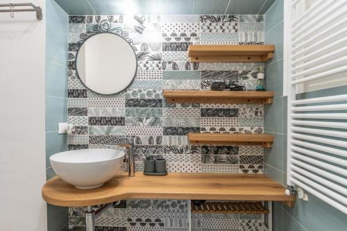 a bathroom with a sink and a mirror at La Vecchia Sartoria, Caldonazzo Ospitar in Caldonazzo