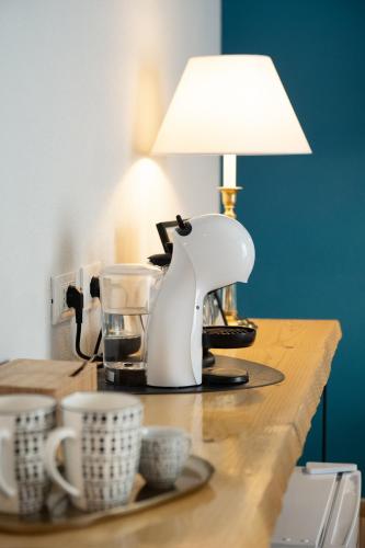 a table with a coffee maker and cups on it at Bianca Elegance Rooms in La Spezia