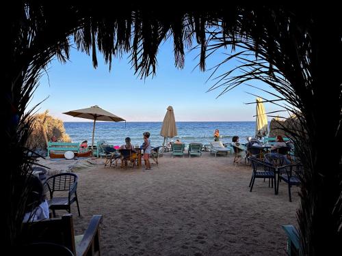 a group of people sitting at tables on the beach at Amanda beach hotel in Dahab