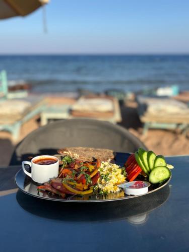 a plate of food and a cup of coffee on a table at Amanda beach hotel in Dahab