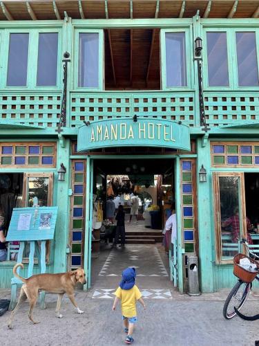 a child and a dog walking in front of a building at Amanda beach hotel in Dahab