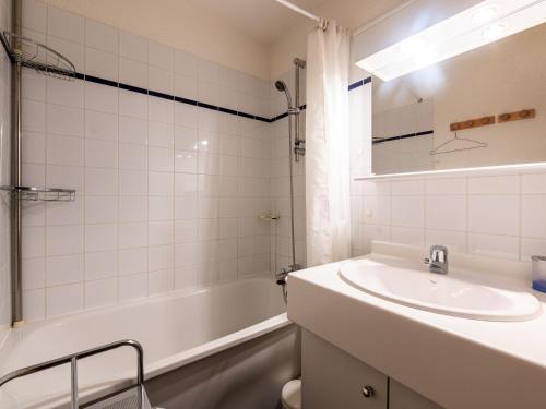 Un baño con lavabo, bañera y espejo. en Les Eterlous - 8 - Appt Montagne 4-6 pers, en Morillon