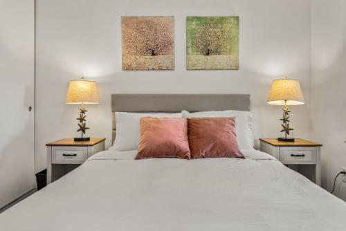 a bedroom with a white bed with two lamps at Parkside Escape Oasis in Bellevue fully fenced in Bellevue