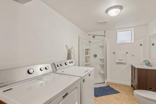 a white bathroom with a toilet and a sink at Parkside Escape Oasis in Bellevue fully fenced in Bellevue