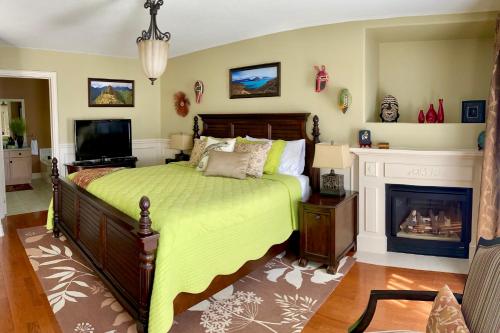 a bedroom with a green bed and a fireplace at Explorer House Bed & Breakfast in Niagara on the Lake