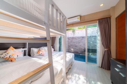 a bedroom with two bunk beds and a balcony at Cazy pool villa pattaya in Jomtien Beach