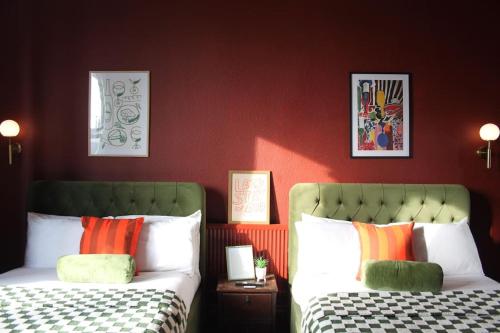 two beds in a room with red walls at Stylish Digbeth Apartment, Sleeps 12 Opposite Birmingham Coach Station, perfect for large groups contractors in Birmingham
