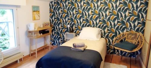 - une chambre avec un lit et un mur à motifs dans l'établissement Chambre d'hôtes DOLCE FARNIENTE, à La Roche-sur-Yon