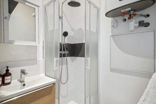 une douche avec une porte vitrée à côté d'un lavabo dans l'établissement La Studette - Deux pas du quartier Gratte-Ciel, à Villeurbanne