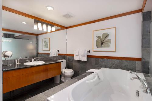 a bathroom with a tub and a toilet and a sink at Le Chamois by Whistler Premier in Whistler
