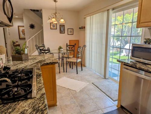 a kitchen and living room with a table and chairs at 5 Minutes to South Bay Beaches! Private 2 bedroom 2 bath 2 level home with patio Excellent value! in Torrance