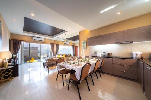 a kitchen and living room with a table and chairs at Cazy pool villa pattaya in Jomtien Beach