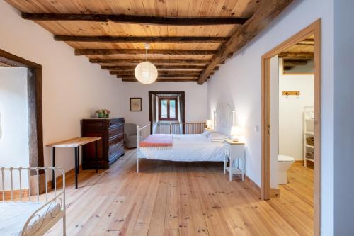 a bedroom with two beds and a wooden ceiling at Quinta da Maria Mendes in Serpins