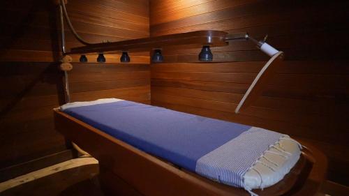 a small bed in a room with wooden walls at Royal Tulip Taj Sultan in Hammamet