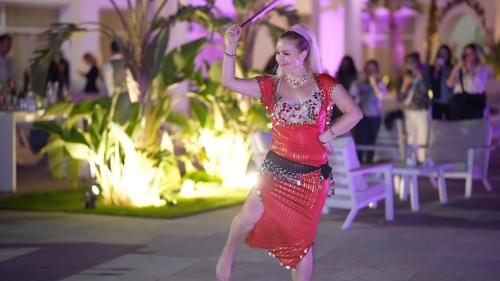 a woman in a red dress is dancing at Royal Tulip Taj Sultan in Hammamet