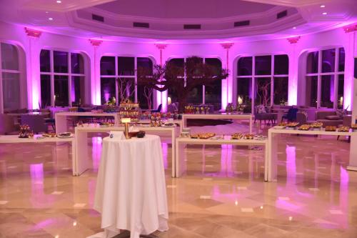 a room with white tables and purple lighting at Royal Tulip Taj Sultan in Hammamet