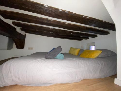 un grand lit dans une chambre avec des plafonds en bois dans l'établissement La mezzanine du Maire - 352, à Rouen