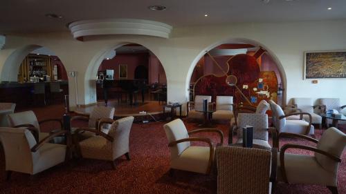 a room with a bunch of chairs and tables at Royal Tulip Taj Sultan in Hammamet